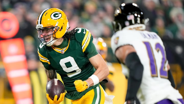 Dec 27, 2025; Green Bay, Wisconsin, USA; Green Bay Packers wide receiver Christian Watson (9) scores a touchdown past Baltimore Ravens safety Alohi Gilman (12) during the first quarter at Lambeau Field. Mandatory Credit: Kayla Wolf-Imagn Images