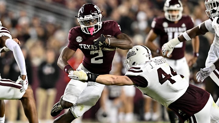 Nov 11, 2023; College Station, Texas, USA; Texas A&M Aggies running back Rueben Owens (2) runs the ball during the second half as Mississippi State Bulldogs linebacker Jett Johnson (44) defends at Kyle Field. Mandatory Credit: Maria Lysaker-Imagn Images
