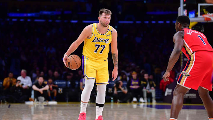 Mar 4, 2025; Los Angeles, California, USA; Los Angeles Lakers guard Luka Doncic (77) controls the ball against New Orleans Pelicans forward Zion Williamson (1) during the first half at Crypto.com Arena. Mandatory Credit: Gary A. Vasquez-Imagn Images