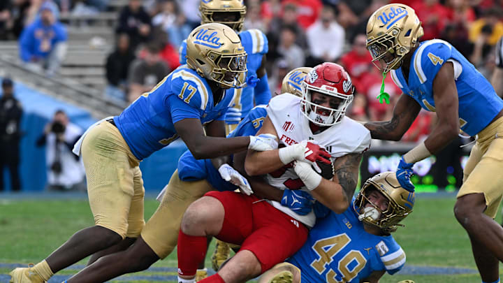 Nov 30, 2024; Pasadena, California, USA; UCLA Bruins linebacker Jalen Woods (17), defensive back Jaylin Davies (6), linebacker Carson Schwesinger (49), and UCLA Bruins defensive back Bryan Addison (4) tackle Fresno State Bulldogs tight end Jake Tarwater (87) during the third quarter at Rose Bowl. Mandatory Credit: Robert Hanashiro-Imagn Images