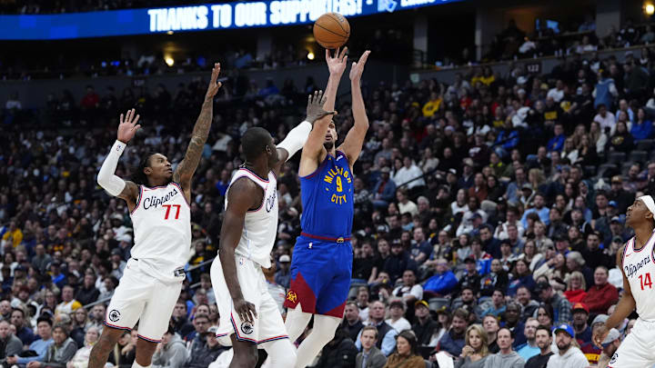 Jan 8, 2025; Denver, Colorado, USA; Denver Nuggets forward Dario Saric (9) shoots the ball over LA Clippers guard Kevin Porter Jr. (77) and center Mo Bamba (4) in the fourth quarter at Ball Arena. Mandatory Credit: Ron Chenoy-Imagn Images Jan 8, 2025; Denver, Colorado, USA; Denver Nuggets forward Dario Saric (9) shoots the ball over LA Clippers guard Kevin Porter Jr. (77) and center Mo Bamba (4) in the fourth quarter at Ball Arena. Mandatory Credit: Ron Chenoy-Imagn Images