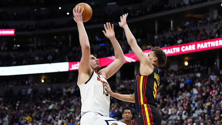 Jan 1, 2025; Denver, Colorado, USA; Atlanta Hawks guard Dyson Daniels (5) defends on Denver Nuggets center Nikola Jokic (15) in the second quarter at Ball Arena. Mandatory Credit: Ron Chenoy-Imagn Images