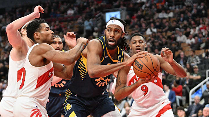 Apr 9, 2024; Toronto, Ontario, CAN;  Indiana Pacers forward Isaiah Jackson (22) prepares to pass the ball away from Toronto Raptors guard Ochai Agbaji (30) and forward RJ Barrett (9) in the second half at Scotiabank Arena. Mandatory Credit: Dan Hamilton-Imagn Images