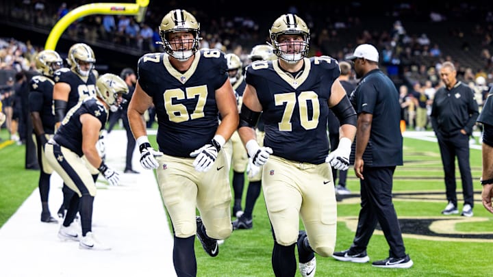 Aug 25, 2024; New Orleans, Louisiana, USA;  New Orleans Saints offensive tackle Trevor Penning (70) and offensive tackle Landon Young (67) during the warmups before the game against the Tennessee Titans at Caesars Superdome. Mandatory Credit: Stephen Lew-Imagn Images