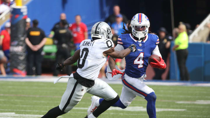Bills running back James Cook tries to run outside of Raiders Jakorian Bennett.