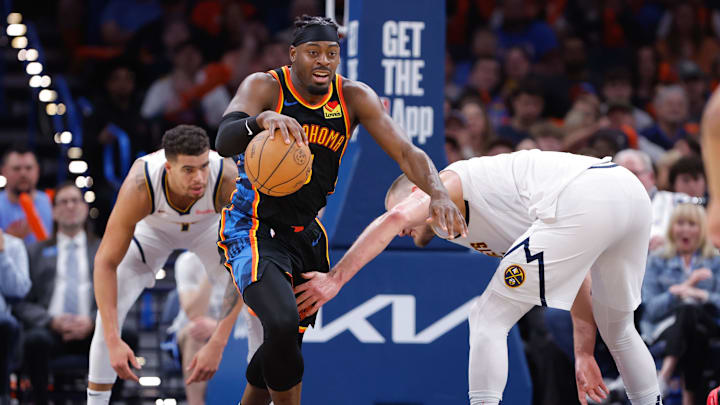 Mar 9, 2025; Oklahoma City, Oklahoma, USA; Oklahoma City Thunder guard Luguentz Dort (5) grabs a loose ball from Denver Nuggets center Nikola Jokic (15) during the second half at Paycom Center. Mandatory Credit: Alonzo Adams-Imagn Images
