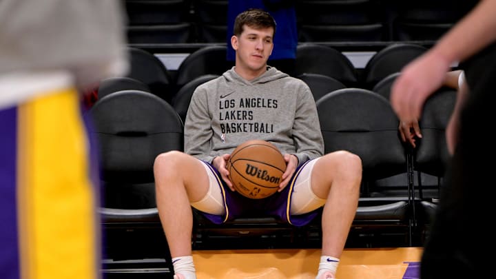 Feb 13, 2024; Los Angeles, California, USA;  Los Angeles Lakers guard Austin Reaves (15) sits in a court side seat as he waits to warm up for a game against the Detroit Pistons at Crypto.com Arena. Mandatory Credit: Jayne Kamin-Oncea-Imagn Images
