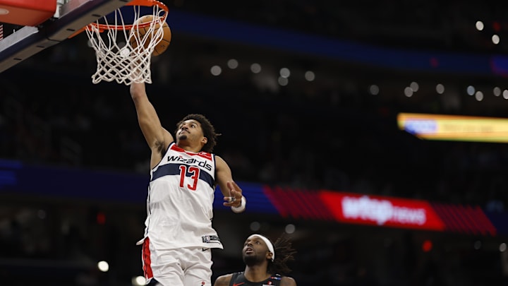 Feb 26, 2025; Washington, District of Columbia, USA; Washington Wizards guard Jordan Poole (13) dunks th ball as Portland Trail Blazers forward Jerami Grant (9) looks on in the second half at Capital One Arena. Mandatory Credit: Geoff Burke-Imagn Images