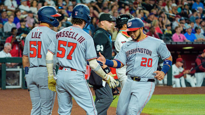 May 31, 2025; Phoenix, Arizona, USA;  Washington Nationals catcher Keibert Ruiz (20) celebrates with outfielder Daylen Lile (51) and outfielder Robert Hassell III (57) after scoring against the Arizona Diamondbacks in the first inning at Chase Field. 