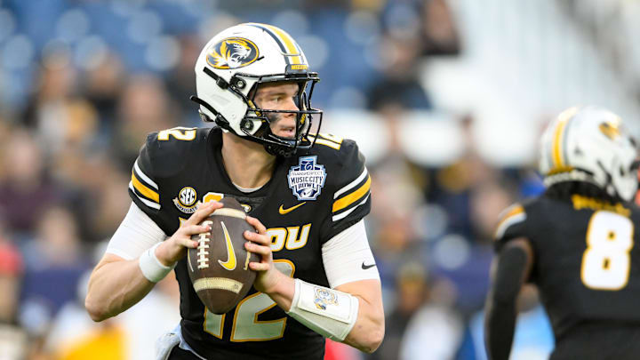 Dec 30, 2024; Nashville, TN, USA;  Missouri Tigers quarterback Brady Cook (12) stands in the pocket against the Iowa Hawkeyes during the second half at Nissan Stadium. Mandatory Credit: Steve Roberts-Imagn Images