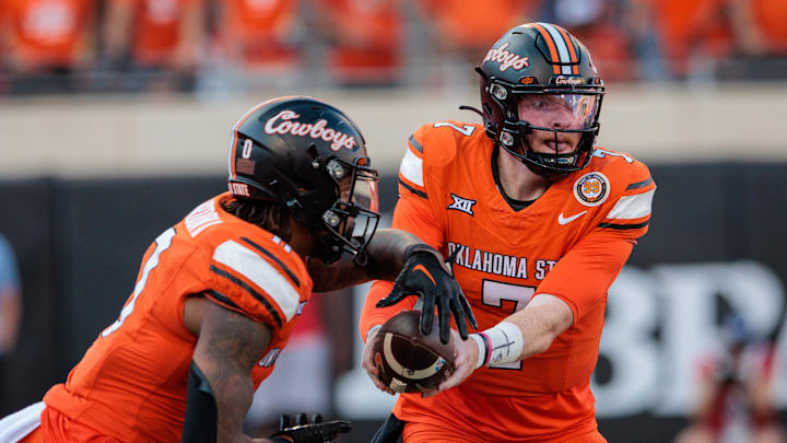 Sep 21, 2024; Stillwater, Oklahoma, USA; Oklahoma State Cowboys quarterback Alan Bowman (7) hands off to running back Ollie Gordon II (0) during the fourth quarter against the Utah Utes at Boone Pickens Stadium. Mandatory Credit: William Purnell-Imagn Images Sep 21, 2024; Stillwater, Oklahoma, USA; Oklahoma State Cowboys quarterback Alan Bowman (7) hands off to running back Ollie Gordon II (0) during the fourth quarter against the Utah Utes at Boone Pickens Stadium. Mandatory Credit: William Purnell-Imagn Images