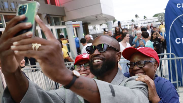 Oct 28, 2024; Miami, Florida, USA; Former Miami Heat guard Dwyane Wade poses with fans in front of the Kaseya Center. Mandatory Credit: Rhona Wise-Imagn Images Oct 28, 2024; Miami, Florida, USA; Former Miami Heat guard Dwyane Wade poses with fans in front of the Kaseya Center. Mandatory Credit: Rhona Wise-Imagn Images