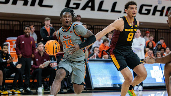 Feb 9, 2025; Stillwater, Oklahoma, USA; Oklahoma State Cowboys guard Jamyron Keller (14) drives to the basket around Arizona State Sun Devils forward Basheer Jihad (8) during the first half at Gallagher-Iba Arena. Mandatory Credit: William Purnell-Imagn Images