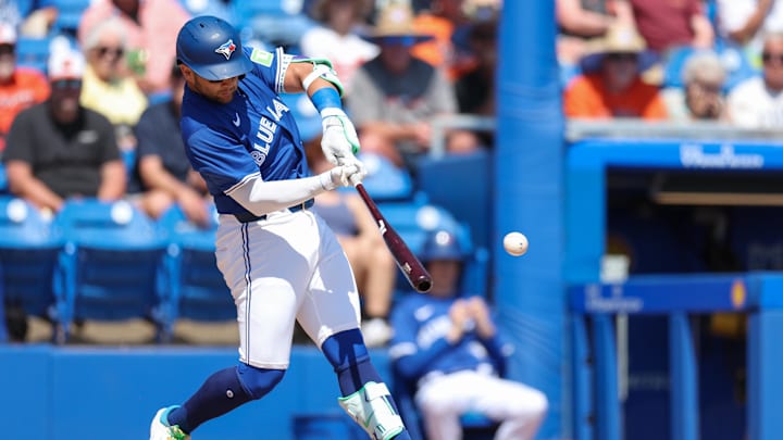 Mar 13, 2025; Dunedin, Florida, USA; Toronto Blue Jays shortstop Bo Bichette (11) hits an rbi single against the Baltimore Orioles in the fifth inning during spring training at TD Ballpark.