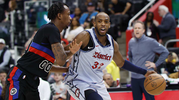 Mar 13, 2025; Detroit, Michigan, USA;  Washington Wizards forward Khris Middleton (32) dribbles defended by Detroit Pistons forward Ronald Holland II (00) in the first half at Little Caesars Arena. Mandatory Credit: Rick Osentoski-Imagn Images
