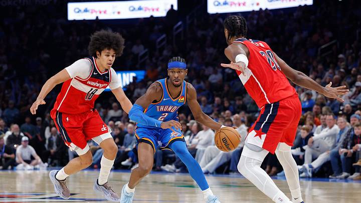 Oct 30, 2025; Oklahoma City, Oklahoma, USA; Oklahoma City Thunder guard Shai Gilgeous-Alexander (2) drives between Washington Wizards forward Kyshawn George (18) and center Alex Sarr (20) during the second half at Paycom Center. Mandatory Credit: Alonzo Adams-Imagn Images Oct 30, 2025; Oklahoma City, Oklahoma, USA; Oklahoma City Thunder guard Shai Gilgeous-Alexander (2) drives between Washington Wizards forward Kyshawn George (18) and center Alex Sarr (20) during the second half at Paycom Center. Mandatory Credit: Alonzo Adams-Imagn Images