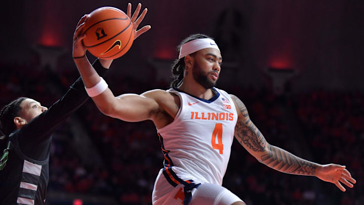 Dec 29, 2024; Champaign, Illinois, USA;  Illinois Fighting Illini guard Kylan Boswell (4) drives past Chicago State Cougars forward Mike Brown (25) and looks to pass during the first half at State Farm Center. Mandatory Credit: Ron Johnson-Imagn Images