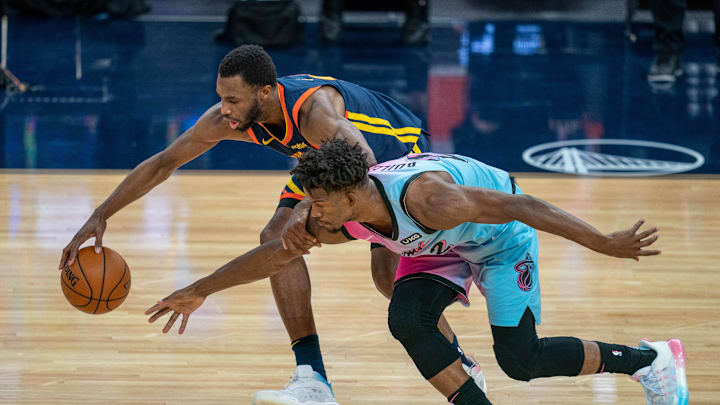 Feb 17, 2021; San Francisco, California, USA; Golden State Warriors forward Andrew Wiggins (22) and Miami Heat forward Jimmy Butler (22) battle for a loose basketball during overtime at Chase Center. Mandatory Credit: Neville E. Guard-Imagn Images