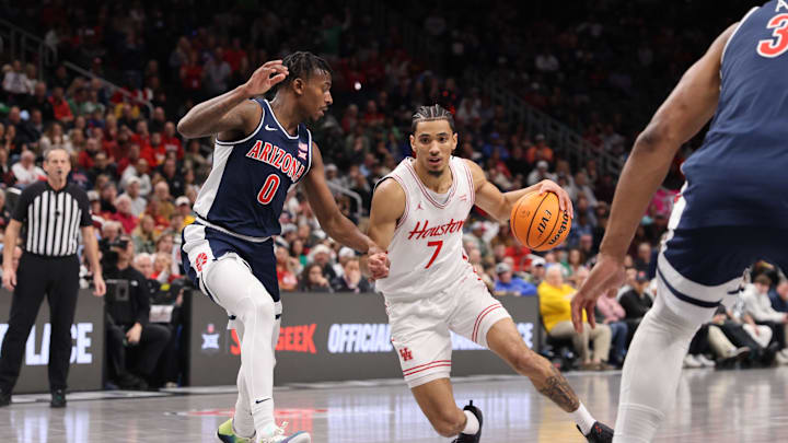 Mar 15, 2025; Kansas City, MO, USA; Houston Cougars guard Milos Uzan (7) dribbles the ball against Arizona Wildcats guard Jaden Bradley (0) during the first half for the Big 12 Conference Tournament Championship game at T-Mobile Center. Mandatory Credit: William Purnell-Imagn Images