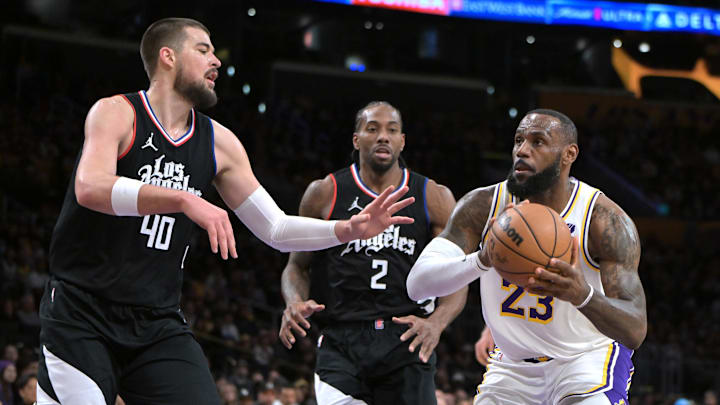 Jan 7, 2024; Los Angeles, California, USA; Los Angeles Lakers forward LeBron James (23) drives past Los Angeles Clippers center Ivica Zubac (40) and forward Kawhi Leonard (2) in the first half at Crypto.com Arena. Mandatory Credit: Jayne Kamin-Oncea-Imagn Images