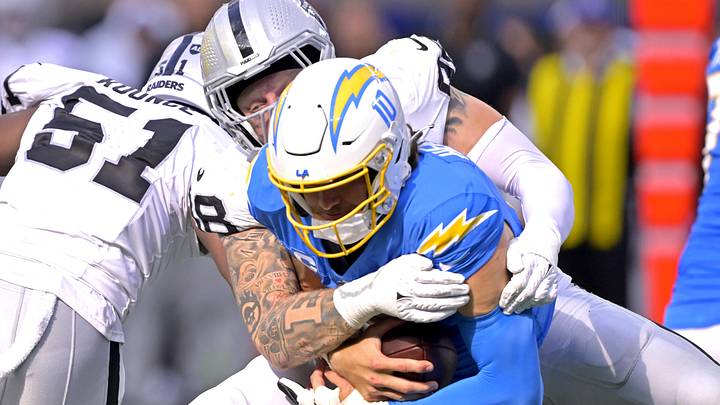 Oct 1, 2023; Inglewood, California, USA;  Los Angeles Chargers quarterback Justin Herbert (10) is sacked by Las Vegas Raiders defensive end Maxx Crosby (98) in the fourth quarter at SoFi Stadium. Mandatory Credit: Jayne Kamin-Oncea-Imagn Images