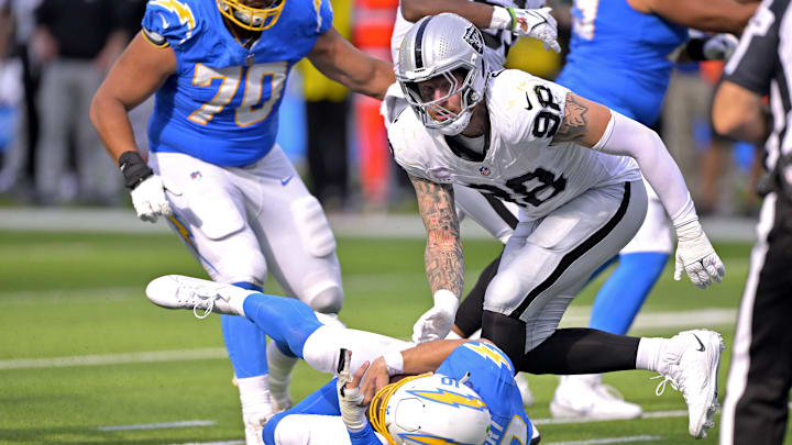 Oct 1, 2023; Inglewood, California, USA;  Los Angeles Chargers quarterback Justin Herbert (10) is sacked by Las Vegas Raiders defensive end Maxx Crosby (98) in the fourth quarter at SoFi Stadium. Mandatory Credit: Jayne Kamin-Oncea-Imagn Images