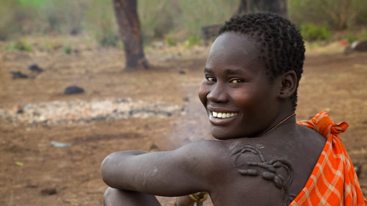 Smiling bodi tribe woman with impressive scarifications on the back, Omo valley, Hana mursi,