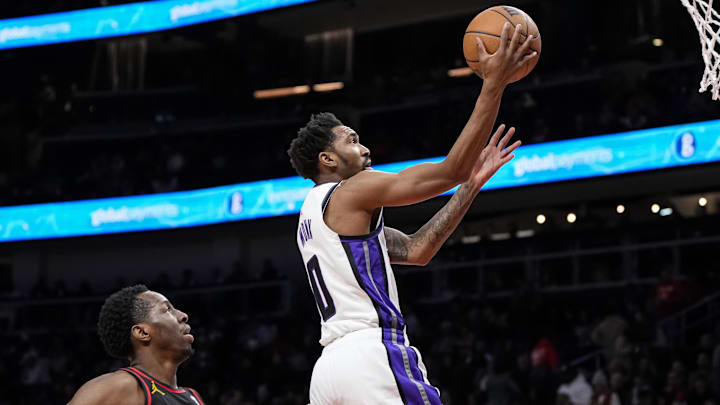 Dec 29, 2023; Atlanta, Georgia, USA; Sacramento Kings guard Malik Monk (0) goes to the basket behind Atlanta Hawks forward Onyeka Okongwu (17) during the first half at State Farm Arena. Mandatory Credit: Dale Zanine-Imagn Images