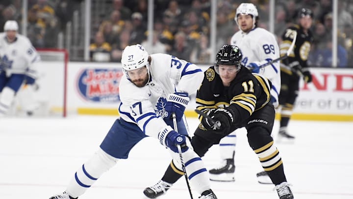 Apr 30, 2024; Boston, Massachusetts, USA; Toronto Maple Leafs defenseman Timothy Liljegren (37) reaches for the puck in front of Boston Bruins center Trent Frederic (11) during the first period in game five of the first round of the 2024 Stanley Cup Playoffs at TD Garden. Mandatory Credit: Bob DeChiara-USA TODAY Sports