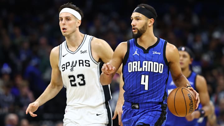 Feb 8, 2024; Orlando, Florida, USA; Orlando Magic guard Jalen Suggs (4) drives to the basket as San Antonio Spurs forward Zach Collins (23) defends during the second quarter at Kia Center. Mandatory Credit: Kim Klement Neitzel-Imagn Images