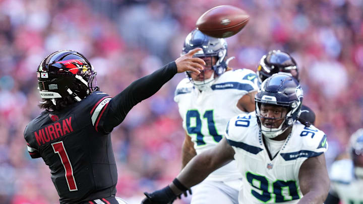 Dec 8, 2024; Glendale, Arizona, USA; Arizona Cardinals quarterback Kyler Murray (1) throws while being pressured by Seattle Seahawks defensive tackle Jarran Reed (90) during the first half at State Farm Stadium. Mandatory Credit: Joe Camporeale-Imagn Images