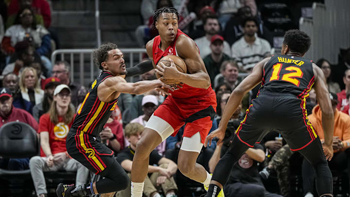 Feb 23, 2024; Atlanta, Georgia, USA; Toronto Raptors forward Scottie Barnes (4) holds the ball defended by Atlanta Hawks guard Trae Young (11) during the first half at State Farm Arena. Mandatory Credit: Dale Zanine-Imagn Images