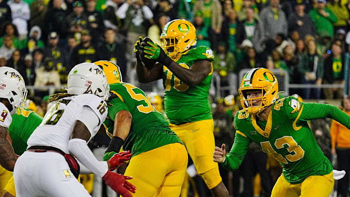 Oregonâ€™s Josh Conerly Jr. takes the the ball on the way to a two-point play against Maryland.