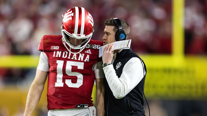 Jan 19, 2026; Miami Gardens, FL, USA; Indiana Hoosiers quarterback Fernando Mendoza (15) with quarterbacks coach Chandler Whitmer against the Miami Hurricanes in the College Football Playoff National Championship game at Hard Rock Stadium. Mandatory Credit: Mark J. Rebilas-Imagn Images