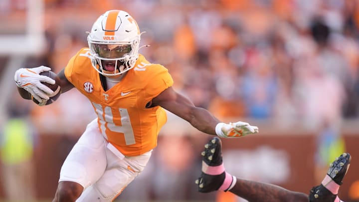 Tennessee wide receiver Braylon Staley (14) keeps going after breaking a tackle from Arkansas defensive back Miguel Mitchell (16) in an NCAA college football game on Oct. 11, 2025, in Knoxville, Tennessee.