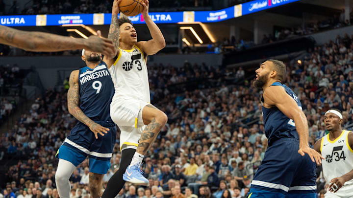 Apr 13, 2025; Minneapolis, Minnesota, USA; Utah Jazz guard Keyonte George (3) drives by the defense of Minnesota Timberwolves guard Nickeil Alexander-Walker (9) and center Rudy Gobert (27) in the fourth quarter at Target Center. Mandatory Credit: Matt Blewett-Imagn Images