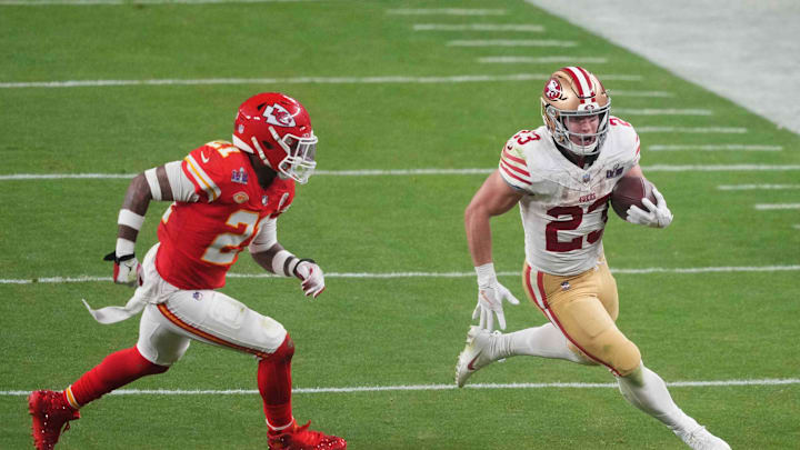 Feb 11, 2024; Paradise, Nevada, USA; San Francisco 49ers running back Christian McCaffrey (23) runs with the ball against Kansas City Chiefs safety Mike Edwards (21) during overtime of Super Bowl LVIII at Allegiant Stadium. Mandatory Credit: Joe Camporeale-Imagn Images