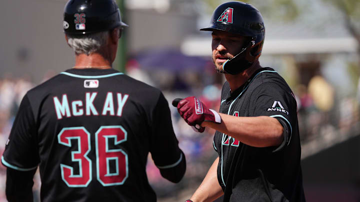 Arizona Diamondbacks' Trey Mancini (3) celebrates his single with first base coach Dave McKay (36) against the Texas Rangers at Surprise Stadium on Sunday, March 2, 2025.