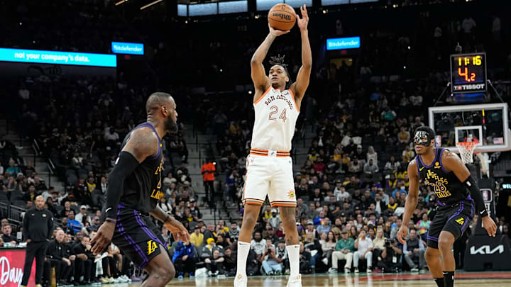 Dec 15, 2023; San Antonio, Texas, USA; San Antonio Spurs guard Devin Vassell (24) while defended by Los Angeles Lakers forwards LeBron James (23) and Rui Hachimura (28) during the first half at Frost Bank Center. Mandatory Credit: Scott Wachter-Imagn Images