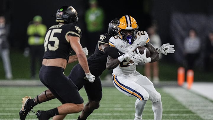 Nov 8, 2024; Winston-Salem, North Carolina, USA; Wake Forest Demon Deacons defensive back Jaxon Mull (12) tackles California Golden Bears running back Jaivian Thomas (25) during the first quarter at Allegacy Federal Credit Union Stadium. Mandatory Credit: Jim Dedmon-Imagn Images
