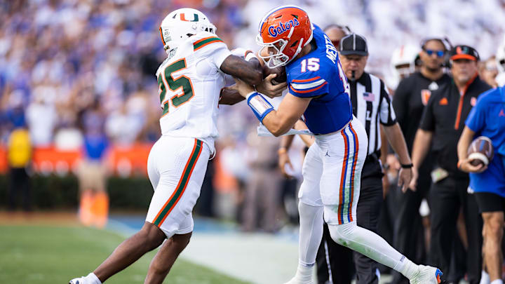 Aug 31, 2024; Gainesville, Florida, USA; Florida Gators quarterback Graham Mertz (15) runs into Miami Hurricanes defensive back Jadais Richard (25) during the first half at Ben Hill Griffin Stadium. Mandatory Credit: Matt Pendleton-Imagn Images