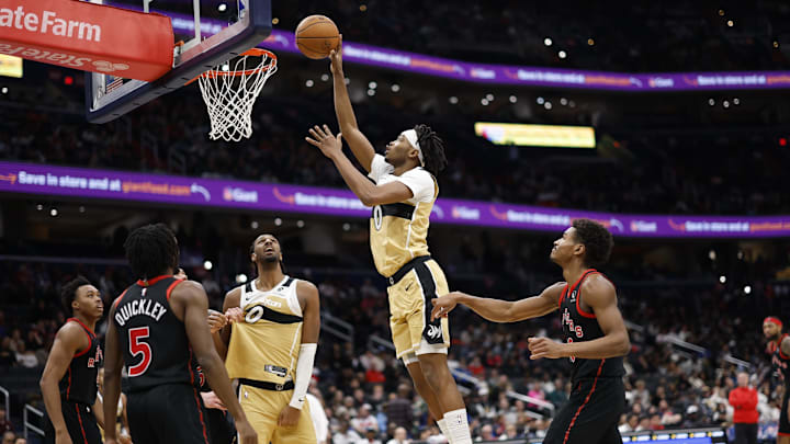 Dec 26, 2025; Washington, District of Columbia, USA; Washington Wizards guard Bilal Coulibaly (0) shoots the ball as Toronto Raptors guard Ochai Agbaji (30) and Raptors guard Immanuel Quickley (5) look on in the second half at Capital One Arena. Mandatory Credit: Geoff Burke-Imagn Images