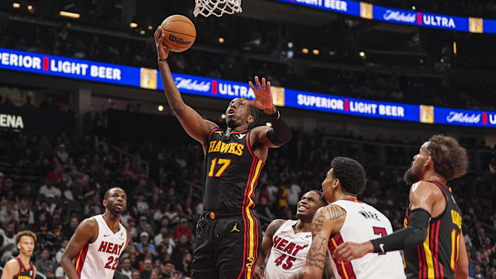 Apr 18, 2025; Atlanta, Georgia, USA; Atlanta Hawks forward Onyeka Okongwu (17) goes to the basket behind Miami Heat guard Davion Mitchell (45) during the first half at State Farm Arena. Mandatory Credit: Dale Zanine-Imagn Images
