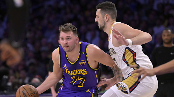 Apr 4, 2025; Los Angeles, California, USA;  Los Angeles Lakers guard Luka Doncic (77) is defended by New Orleans Pelicans center Karlo Matkovic (17) in the first half at Crypto.com Arena. Mandatory Credit: Jayne Kamin-Oncea-Imagn Images