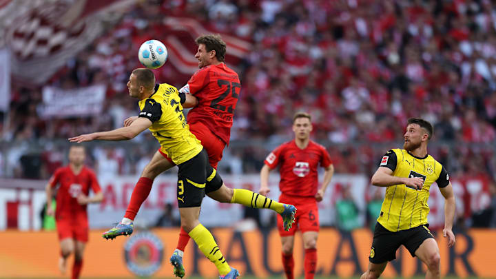 Waldemar Anton and Thomas Müller battle for the ball in a match that shared points between Borussia Dortmund and Bayern Munich.