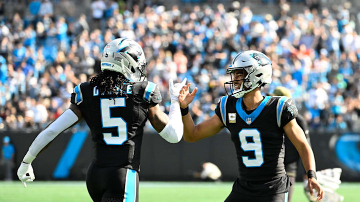 Nov 9, 2025; Charlotte, North Carolina, USA;  Carolina Panthers running back Rico Dowdle (5) celebrates with quarterback Bryce Young (9) after scoring a touchdown  in the first quarter at Bank of America Stadium. Mandatory Credit: Bob Donnan-Imagn Images