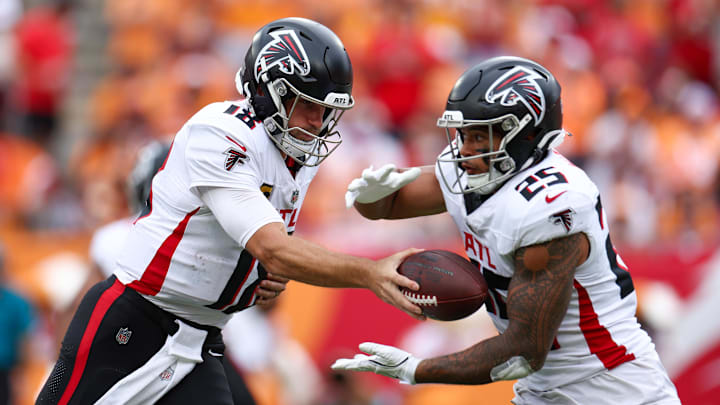 Atlanta Falcons quarterback Kirk Cousins (18) hands off to running back Tyler Allgeier