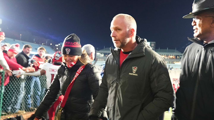 Nov 30, 2024; Chapel Hill, North Carolina, USA; North Carolina State Wolfpack head coach Dave Doreren leaves the field with his wife Sarah after the game at Kenan Memorial Stadium. Mandatory Credit: Bob Donnan-Imagn Images Nov 30, 2024; Chapel Hill, North Carolina, USA; North Carolina State Wolfpack head coach Dave Doreren leaves the field with his wife Sarah after the game at Kenan Memorial Stadium. Mandatory Credit: Bob Donnan-Imagn Images