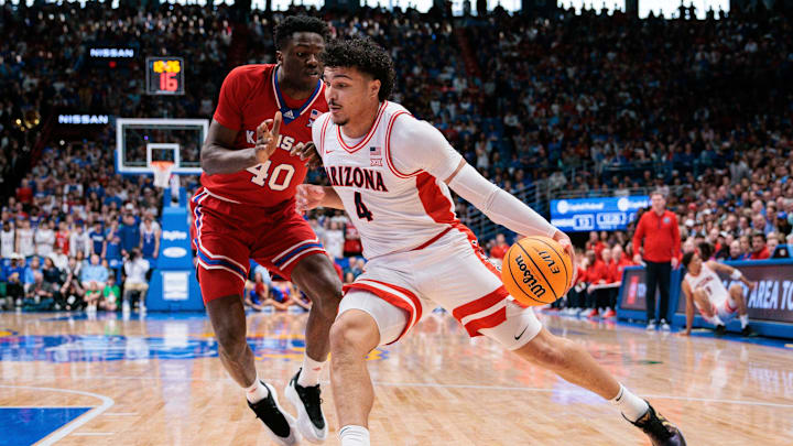 Mar 8, 2025; Lawrence, Kansas, USA; Arizona Wildcats forward Trey Townsend (4) drives to the basket around Kansas Jayhawks forward Flory Bidunga (40) during the first half at Allen Fieldhouse. Mandatory Credit: William Purnell-Imagn Images
