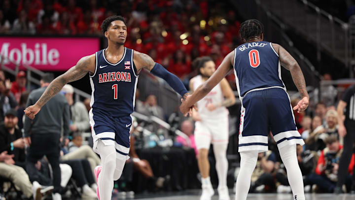 Mar 15, 2025; Kansas City, MO, USA; Arizona Wildcats guard Caleb Love (1) reacts with guard Jaden Bradley (0) against the Houston Cougars during the first half for the Big 12 Conference Tournament Championship game at T-Mobile Center. Mandatory Credit: William Purnell-Imagn Images
